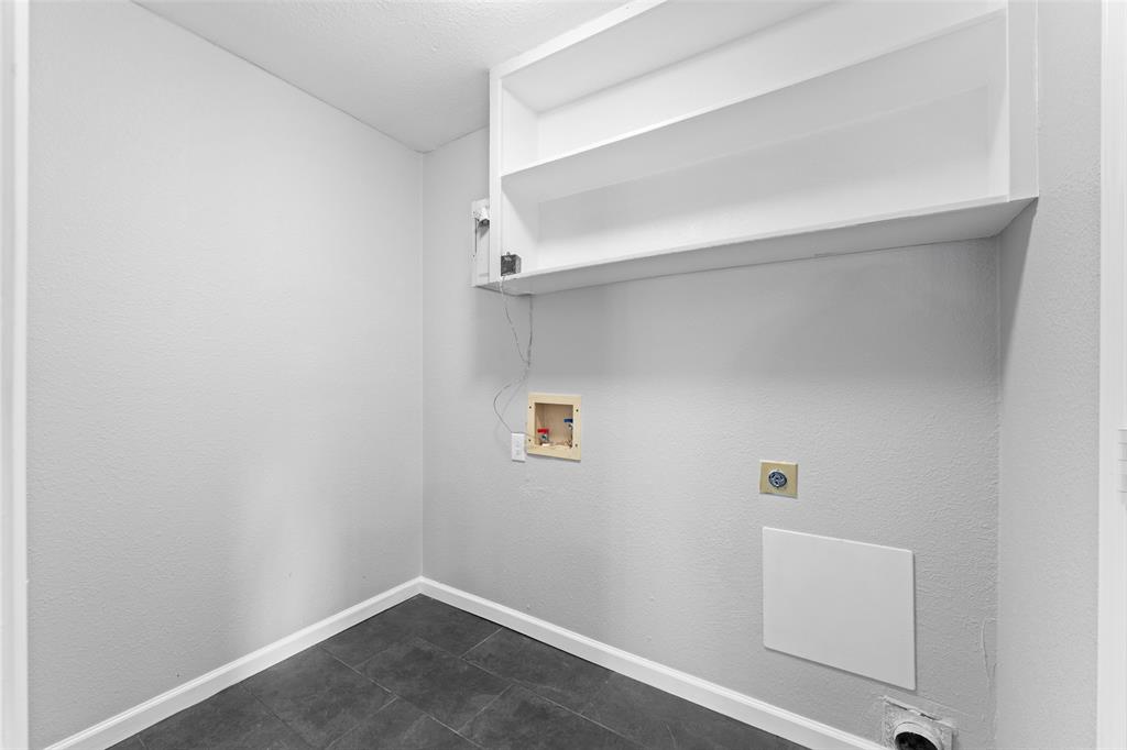 1137 Via Balboa Mesquite, TX 75150 - Photo 14 of 15 Laundry room with hookup for a washing machine, electric dryer hookup, a textured wall, and dark tile patterned flooring