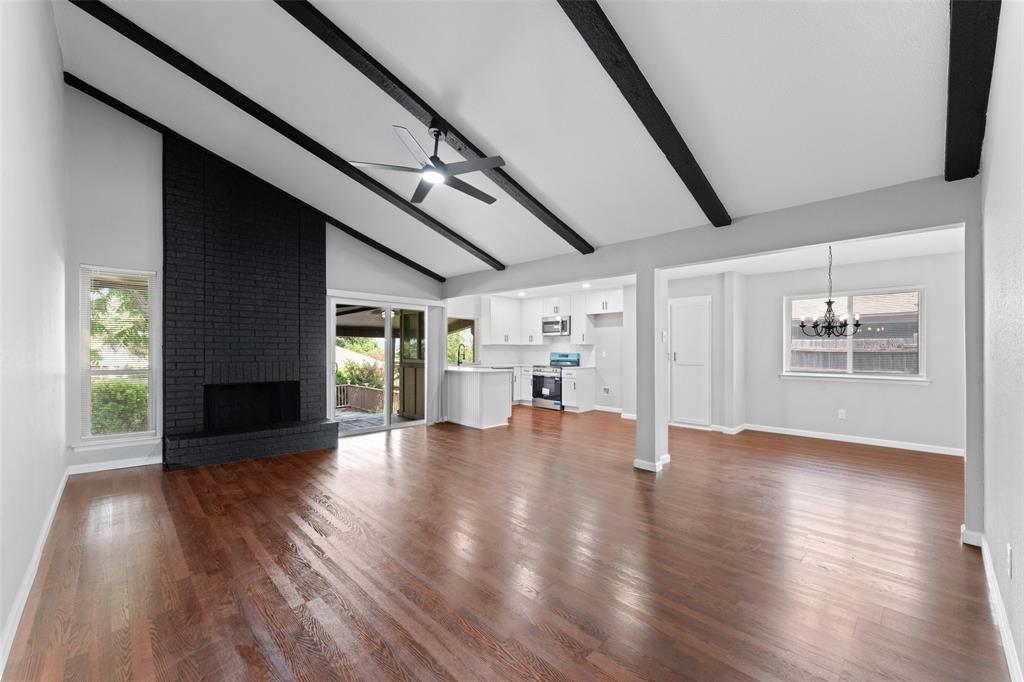 1137 Via Balboa Mesquite, TX 75150 - Photo 2 of 15 Unfurnished living room with a ceiling fan, high vaulted ceiling, a fireplace, dark wood finished floors, and beam ceiling