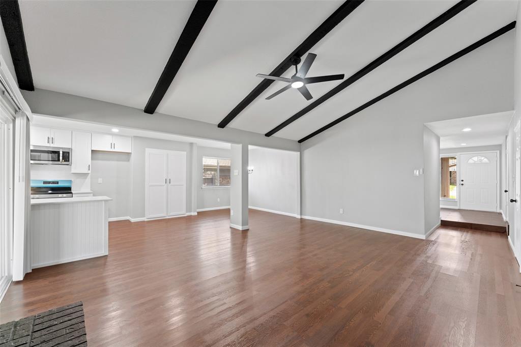 1137 Via Balboa Mesquite, TX 75150 - Photo 3 of 15 Unfurnished living room featuring beam ceiling, dark wood finished floors, a ceiling fan, recessed lighting, and high vaulted ceiling