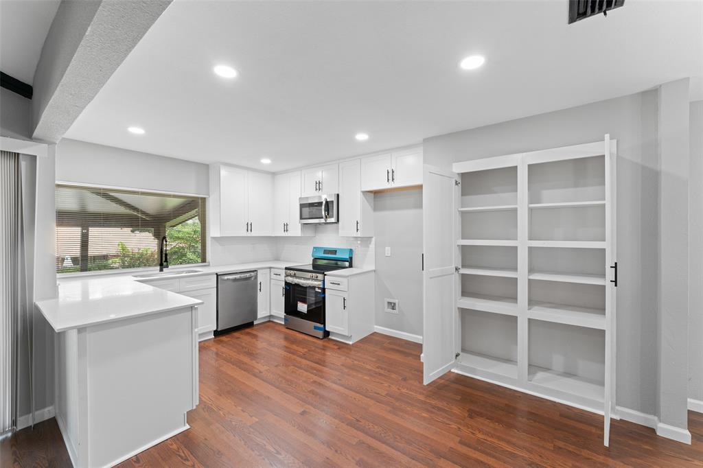 1137 Via Balboa Mesquite, TX 75150 - Photo 5 of 15 Kitchen featuring stainless steel appliances, white cabinets, dark wood-style floors, decorative backsplash, and recessed lighting