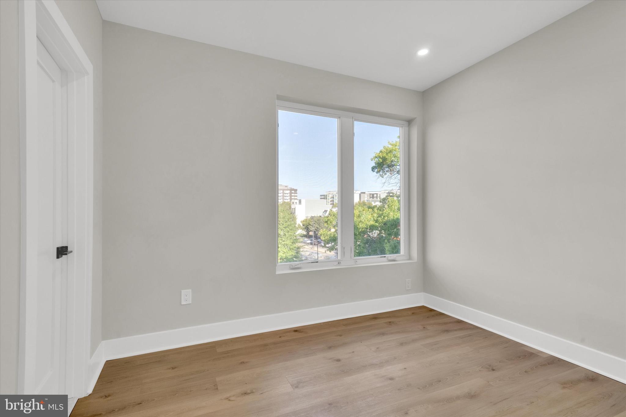 1915 Benning Road Northeast, Unit 9 401 Washington, DC 20002 - Photo 7 of 19 an empty room with wooden floor and windows