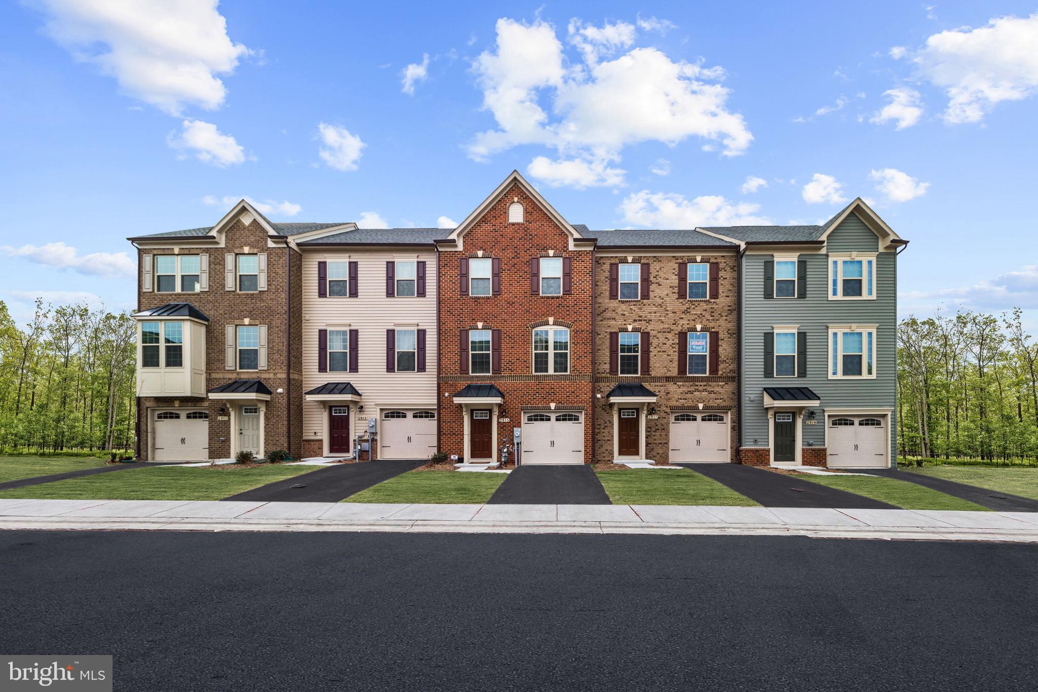 a front view of a residential apartment building with a yard and entryway