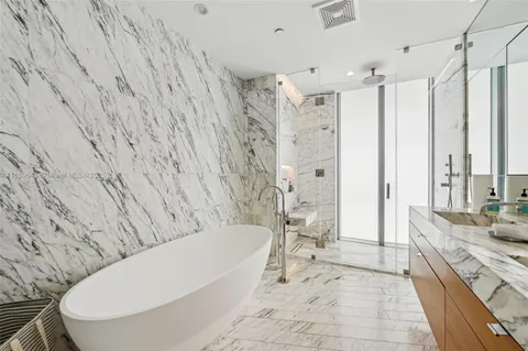 a bathroom with a granite countertop tub sink and mirror