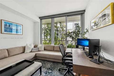 a bedroom with a bed a couch and potted plant