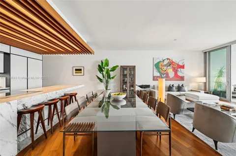 a view of a dining room with furniture a rug and wooden floor