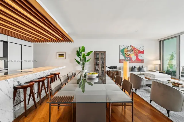 a view of a dining room with furniture a rug and wooden floor