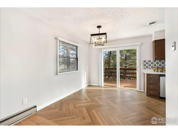 a view of an empty room with a window and cabinet