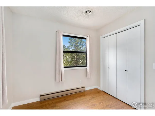 a view of an empty room with window and closet