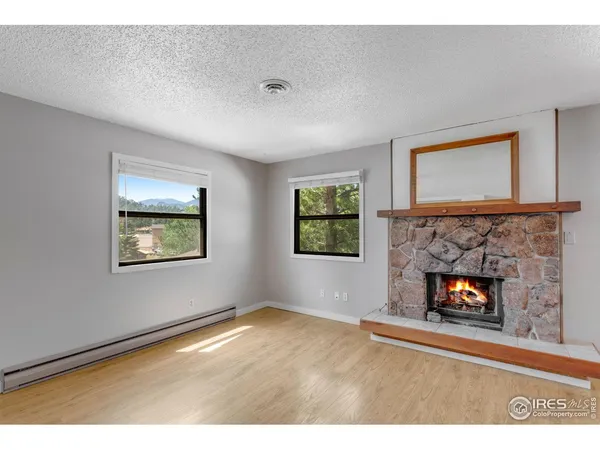 a view of an empty room with window and fire place