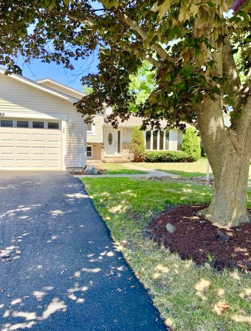 17588 West Summit Drive Grayslake, IL 60030 - Photo 2 of 19 a front view of a house with a garden and trees
