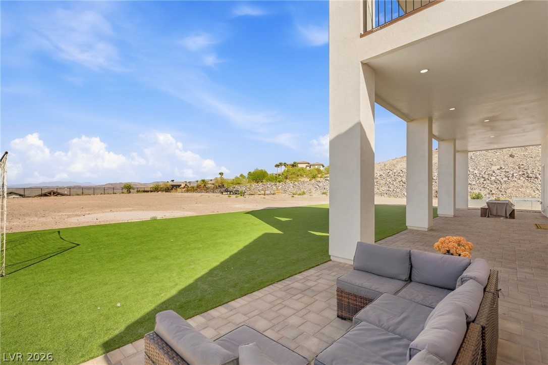 324 Wanda Road Henderson, NV 89002 - Photo 60 of 96 Shaded paver patios overlook a sprawling green lawn and distant mountain views.