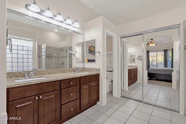 a spacious bathroom with a granite countertop sink a mirror and a shower