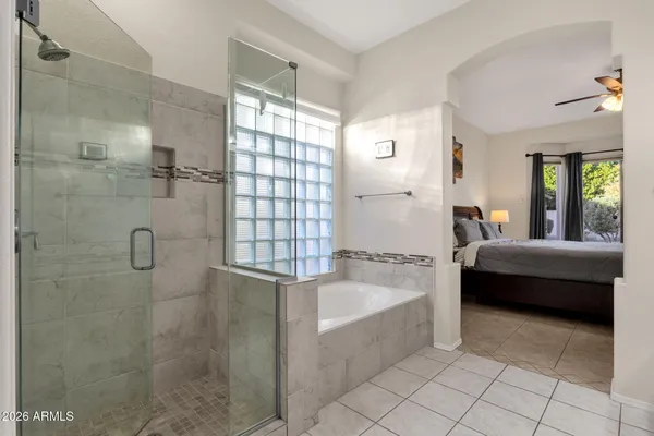 a spacious bathroom with a tub shower and mirror