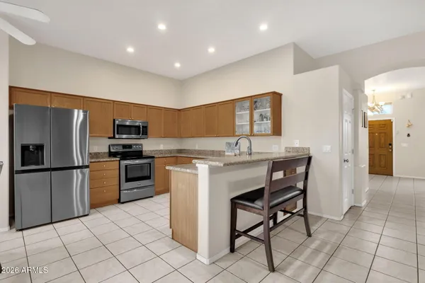 a kitchen with stainless steel appliances kitchen island granite countertop a refrigerator and a stove top oven