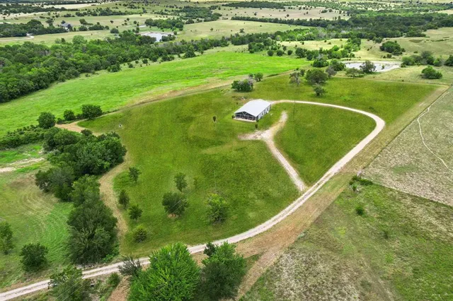 a view of a green yard with large trees
