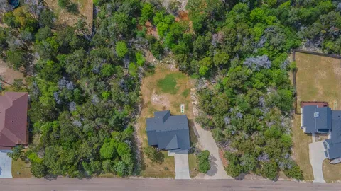 an aerial view of a house with a yard and lake view