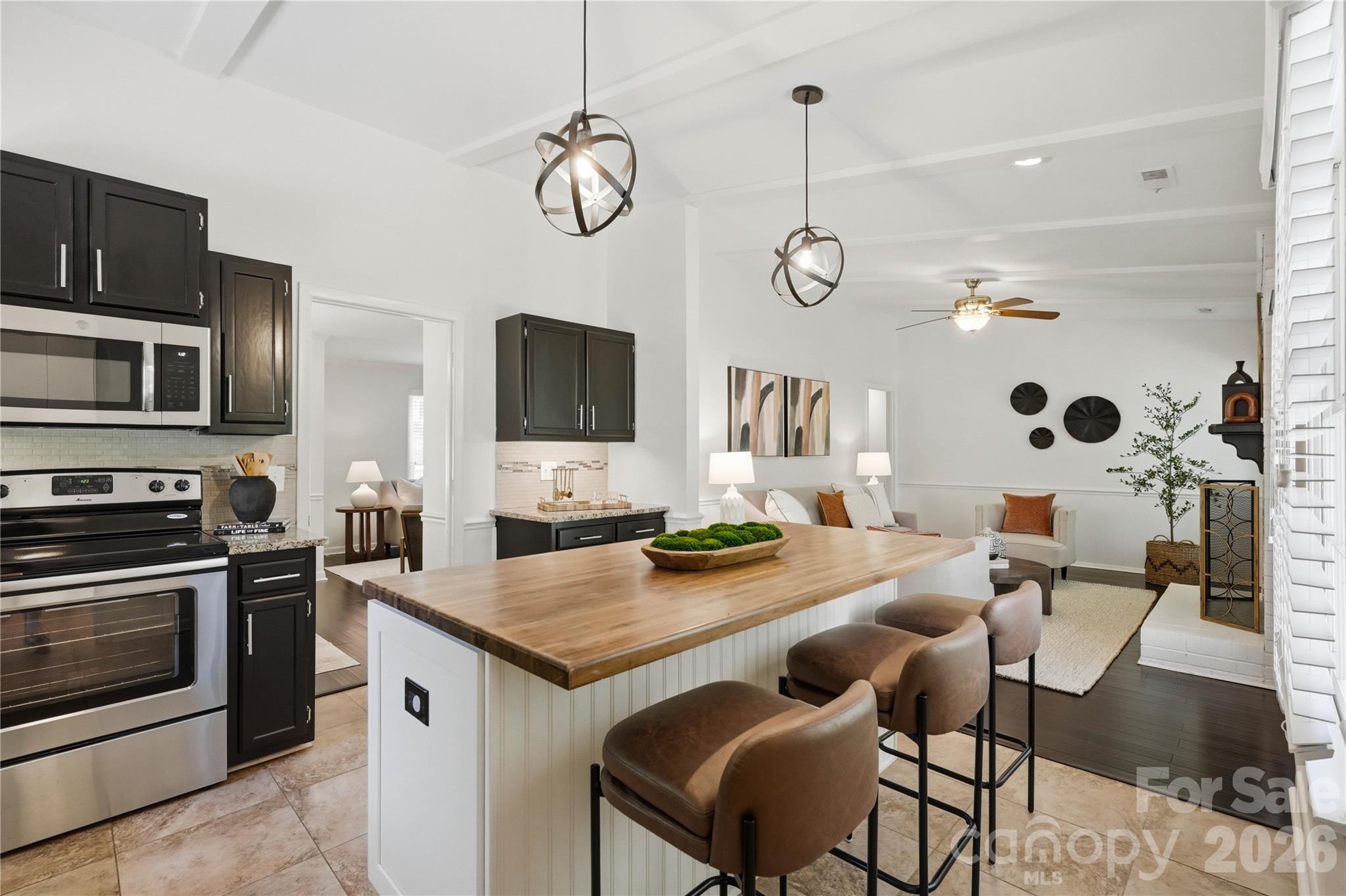 341 Neill Ridge Road Matthews, NC 28105 - Photo 16 of 36 a kitchen with granite countertop stainless steel appliances a stove a sink a dining table and chairs with wooden floor