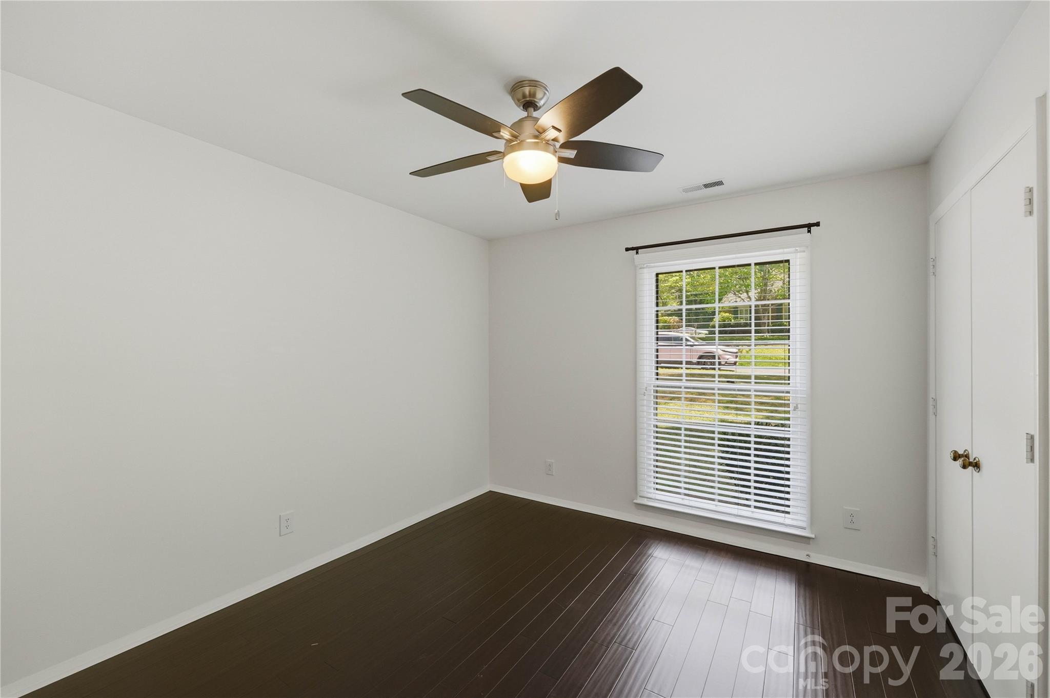 341 Neill Ridge Road Matthews, NC 28105 - Photo 29 of 36 an empty room with wooden floor fan and windows