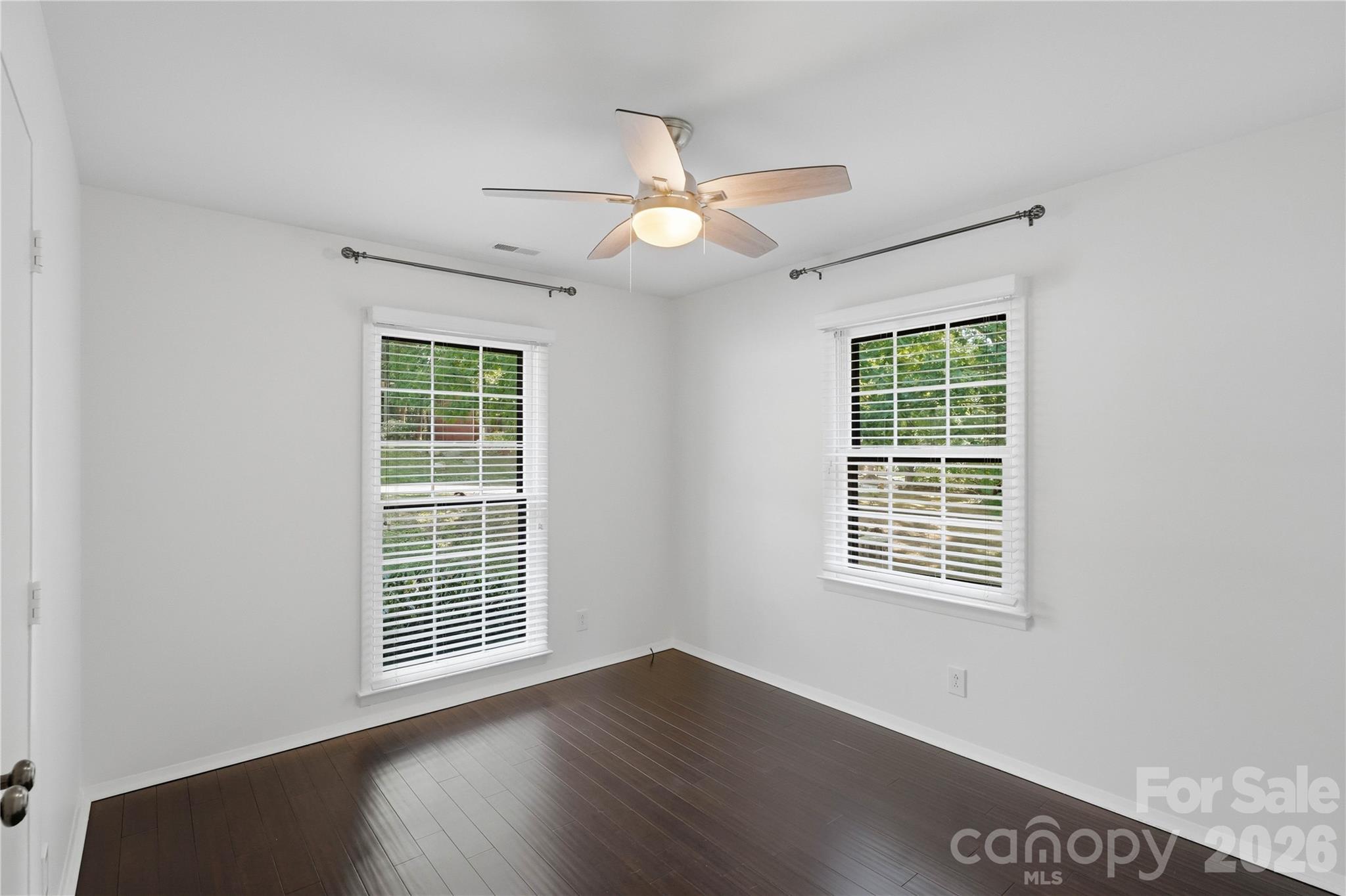 341 Neill Ridge Road Matthews, NC 28105 - Photo 31 of 36 an empty room with wooden floor chandelier fan and windows