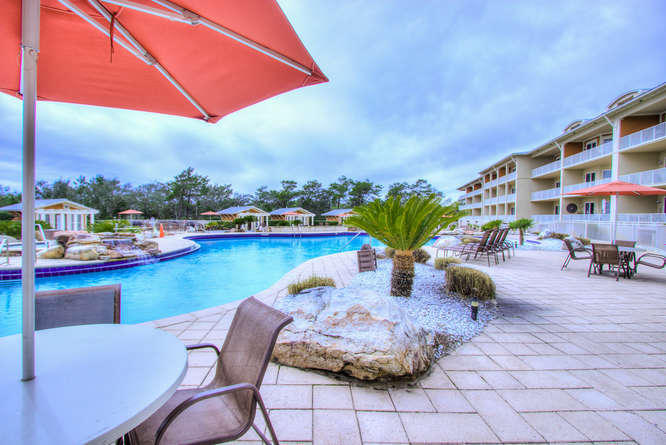 1653 West County Highway 30A, Unit 1116 Santa Rosa Beach, FL 32459 - Photo 26 of 41 a view of a lake with couches chairs and a table