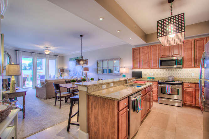 1653 West County Highway 30A, Unit 1116 Santa Rosa Beach, FL 32459 - Photo 6 of 41 a kitchen with stainless steel appliances granite countertop a stove top oven a refrigerator a sink dishwasher a dining table and chairs with wooden floor