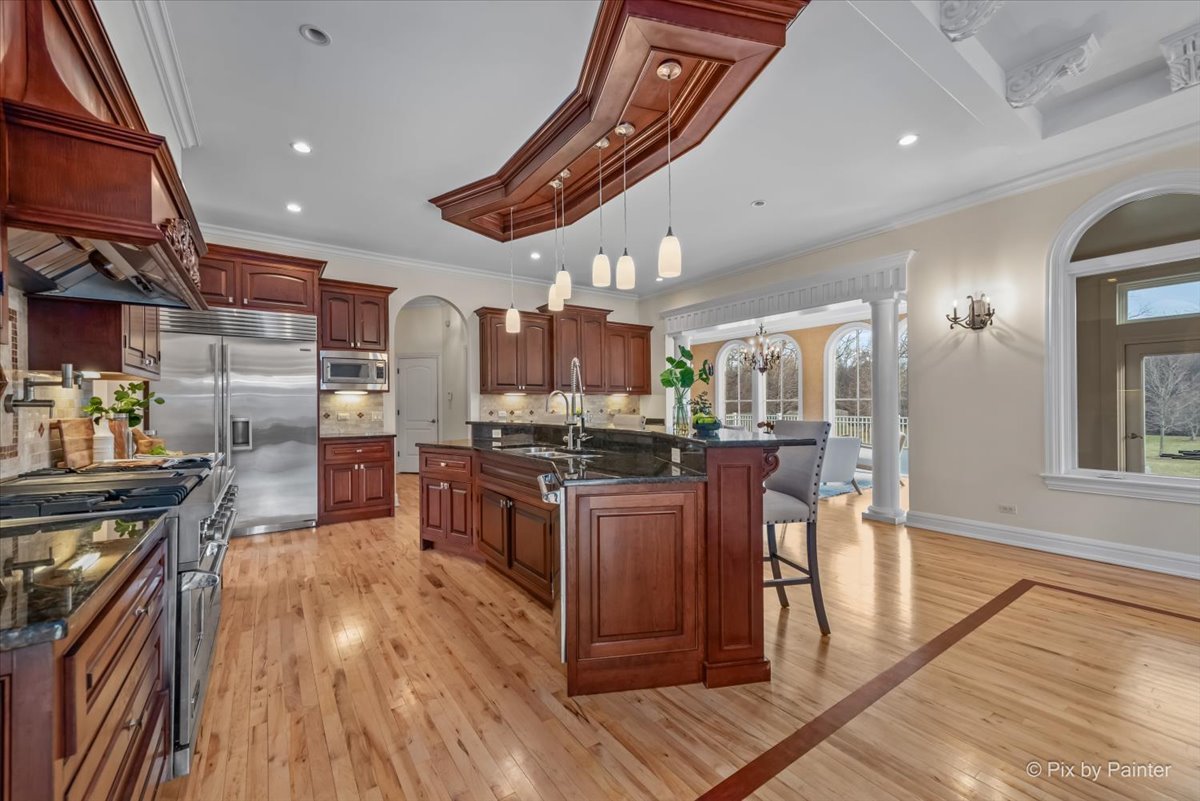 27 West Onwentsia Road Lake Forest, IL 60045 - Photo 19 of 73 a kitchen with stainless steel appliances kitchen island granite countertop a stove and a wooden floors