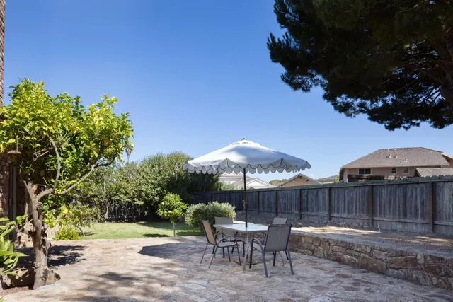 a backyard of a house with table and chairs