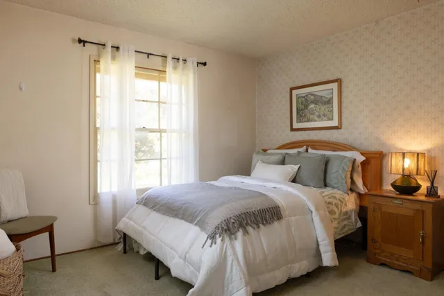 a bedroom with a bed and lamp next to a window