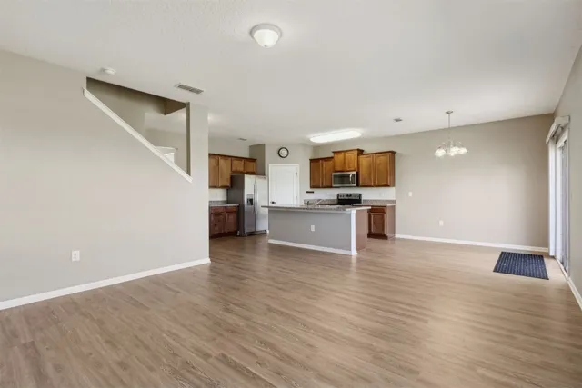 a view of kitchen with microwave refrigerator and cabinets