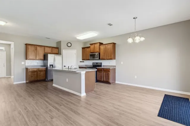 a view of kitchen with wooden floor and electronic appliances