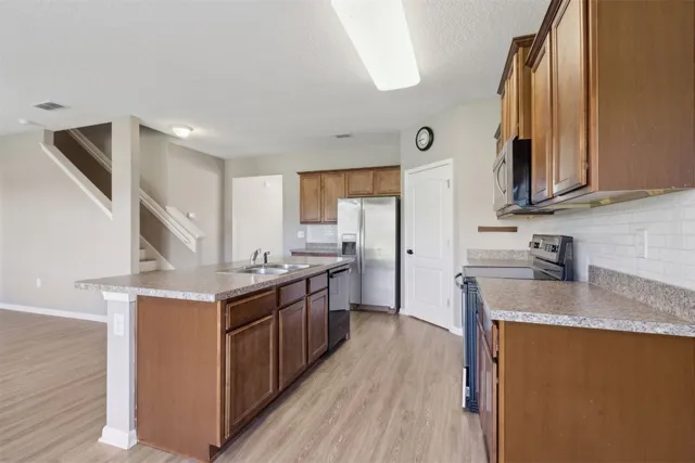 a kitchen with a refrigerator and a stove top oven