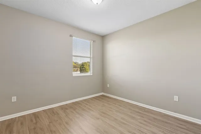 a view of an empty room with wooden floor