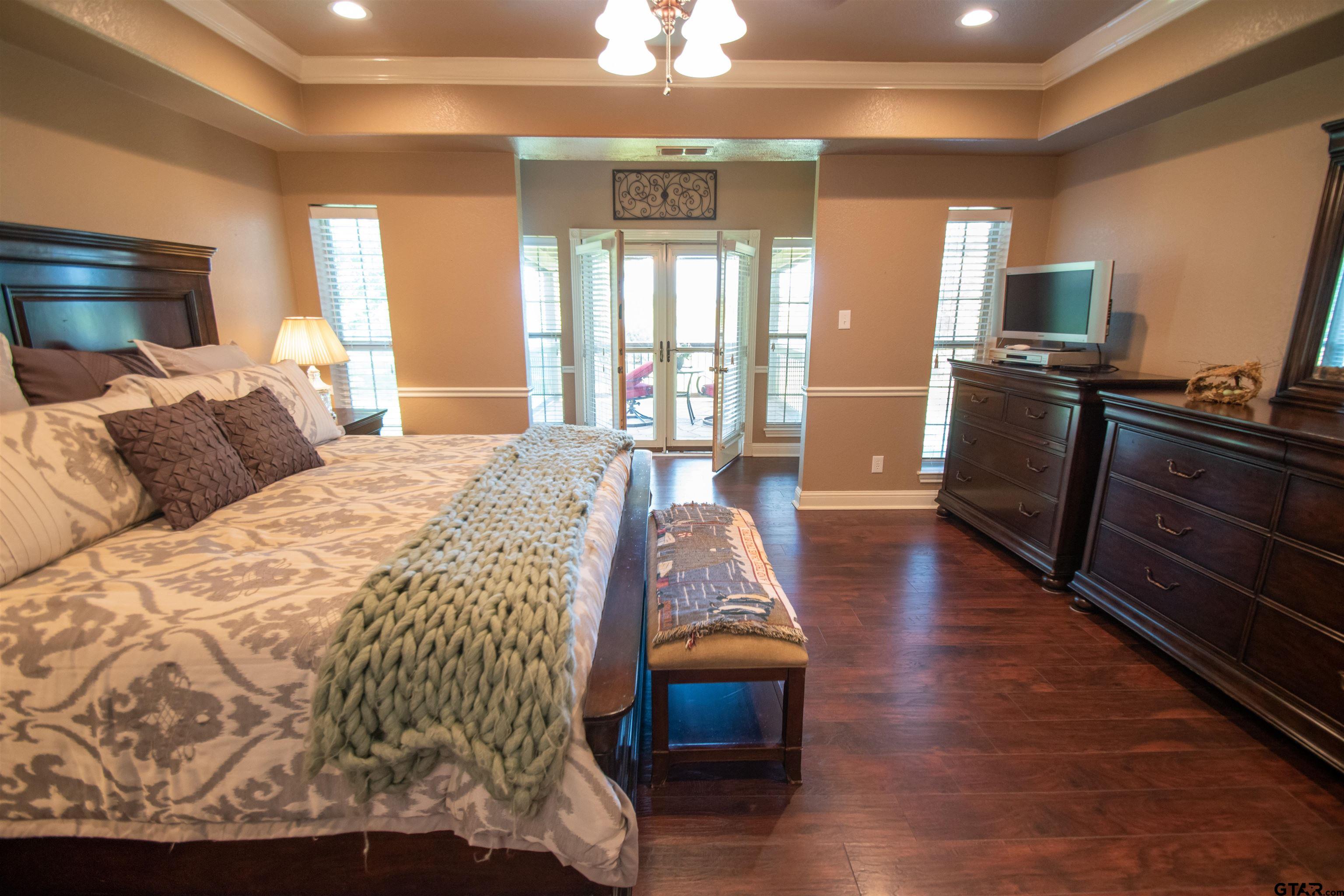 23120 Saddle Ridge Court Lindale, TX 75771 - Photo 11 of 34 a spacious bedroom with a bed and wooden floor
