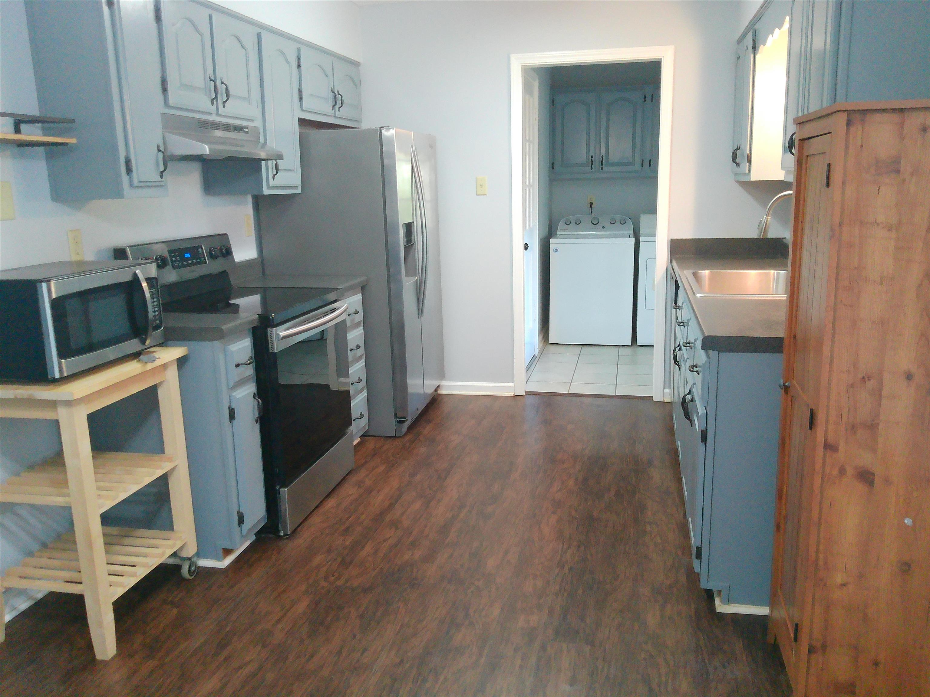 336 Pwr Loop Munford, TN 38058 - Photo 4 of 24 Kitchen featuring appliances with stainless steel finishes, sink, dark wood-type flooring, and washing machine and clothes dryer