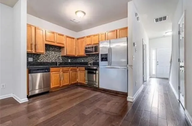 a kitchen with granite countertop a refrigerator and a sink