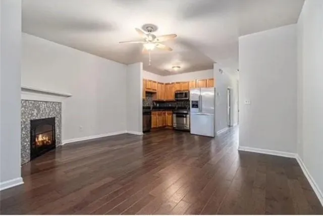 a view of a kitchen with a stove wooden floor ceiling fan and a kitchen