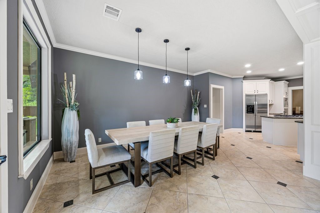 27722 Tiverton Court Spring, TX 77386 - Photo 13 of 33 Everyday Dining with a View! Positioned beside the living room, the informal dining area is ideal for morning coffee, casual meals, and weekend brunches while remaining seamlessly connected to the home's open-concept living spaces.