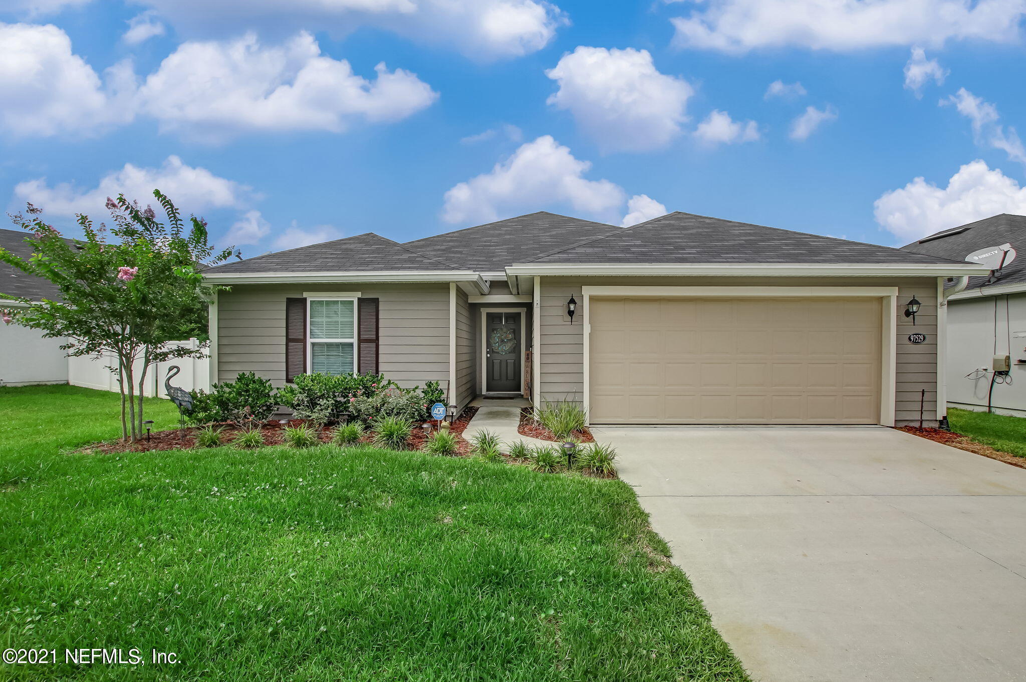 a front view of a house with a garden and yard