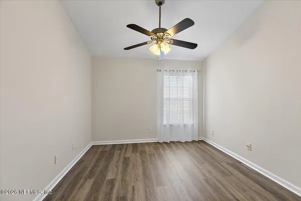 a view of a room with wooden floor and a window