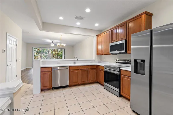 a kitchen with stainless steel appliances granite countertop a refrigerator and a stove top oven