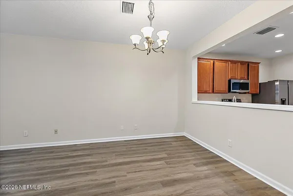a view of a room with wooden floor and chandelier