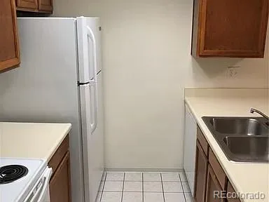 a kitchen with a refrigerator sink and cabinets