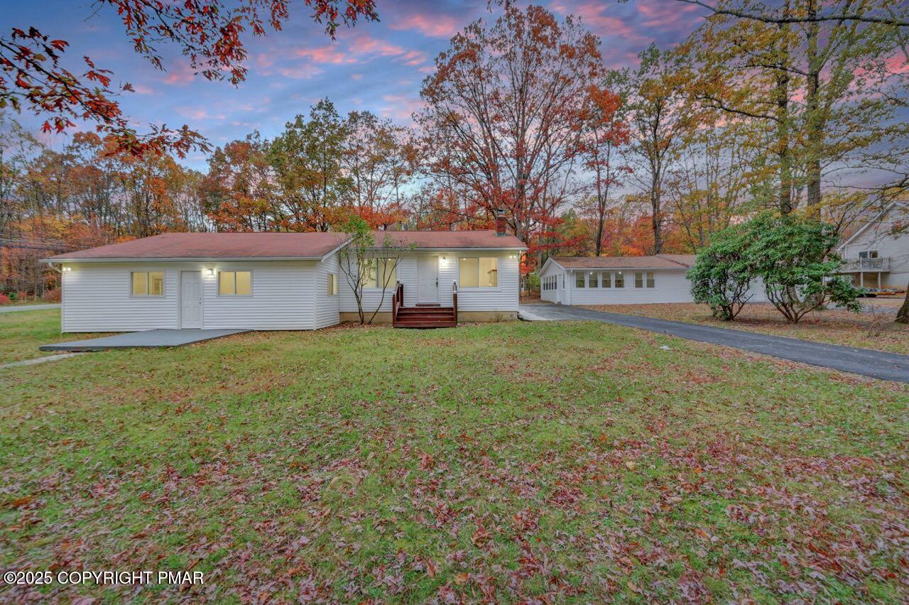 a front view of a house with a garden and trees