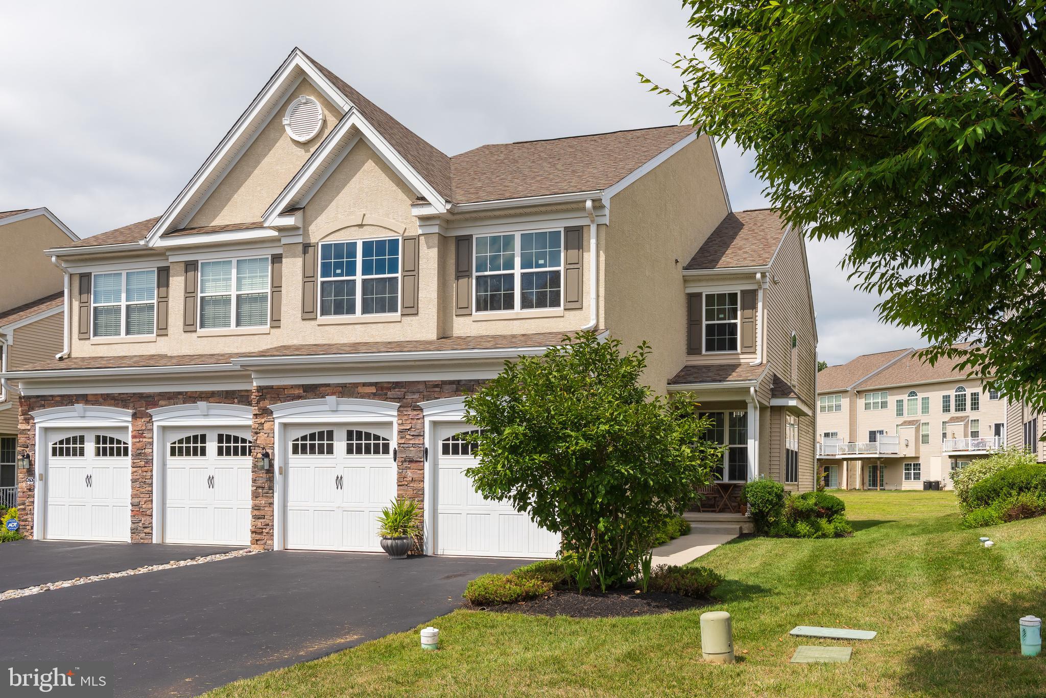 a front view of a house with a yard garage and trees