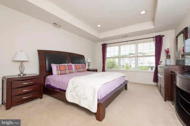 a bedroom with a bed and a large window