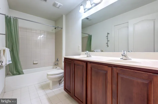 a bathroom with a double vanity sink toilet and shower