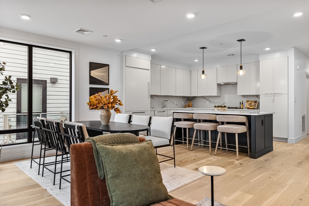 a living room with stainless steel appliances kitchen island granite countertop furniture and a large window