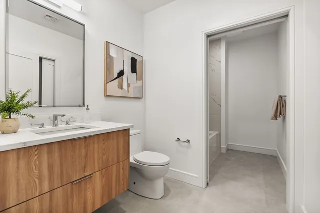 a bathroom with a toilet a sink and mirror