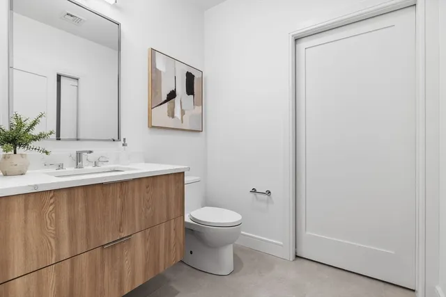 a bathroom with a toilet a sink a vanity and mirror