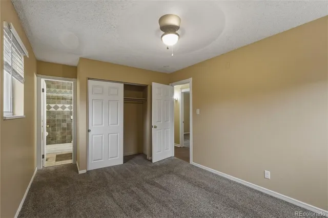 an empty room with chandelier fan and windows